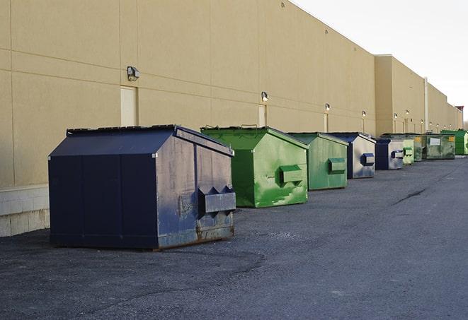 a pile of demolition waste sits beside a dumpster in a parking lot in Byron IL